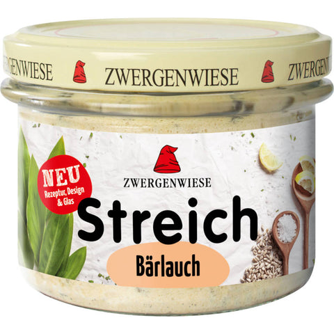 Ein Glas Bärlauch Streich, eine cremige, grüne Aufstrichspezialität aus frischem Bärlauch, ideal zum Verfeinern von Brot und Brötchen.