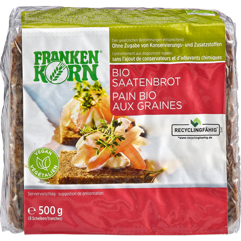 Frisches Saatenbrot mit knuspriger Kruste und einer Mischung aus verschiedenen Samen, auf einem rustikalen Holzbrett serviert.
