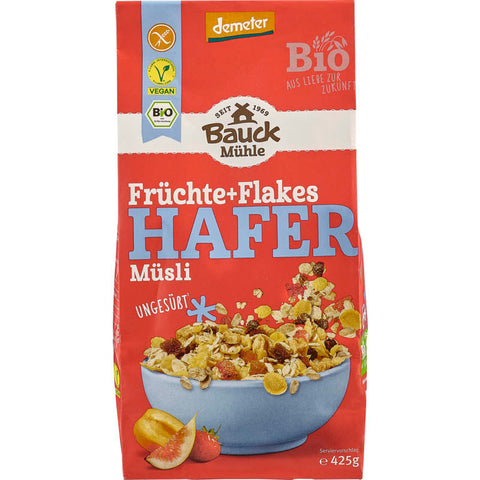 Glutenfreies Hafer Müsli mit Früchten und Flakes in einer Schüssel, umgeben von frischen Beeren und einem Glas Milch.