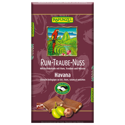 Eine Tafel Schokolade mit Rum-Traube-Nuss-Geschmack, verpackt in einer ansprechenden Hülle. Die Schokolade enthält saftige Rosinen, knackige Nüsse und einen Hauch von Rum, der für ein besonderes Geschmackserlebnis sorgt.
