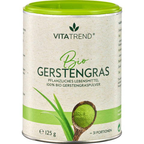 Bio Gerstengras Pulver in einer weißen Schale auf einem Holztisch, umgeben von frischen Gerstengras-Halmen. Das leuchtend grüne Pulver ist fein gemahlen und zeigt seine natürliche, gesunde Farbe.