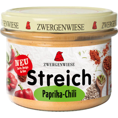 Glas mit Paprika-Chili-Aufstrich, leuchtend rote Farbe, cremige Textur, ideal zum Verfeinern von Brot, Crackern oder als Dip.