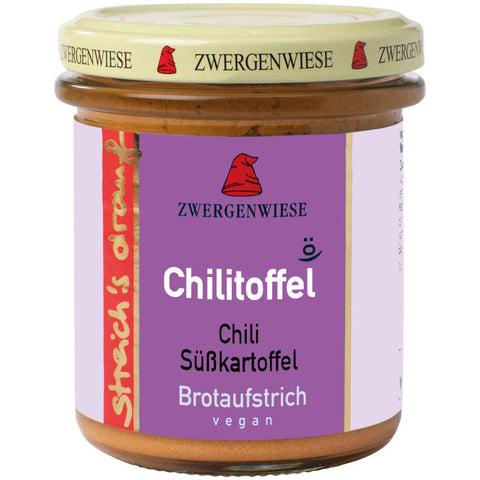 Ein Glas streich´s drauf Chilitoffel, eine würzige Brotaufstrich-Kreation mit Chili und Kartoffeln, präsentiert auf einem rustikalen Holztisch. Der Aufstrich hat eine leuchtend rote Farbe und ist ideal für alle, die scharfe und herzhafte Geschmacksrichtungen lieben.