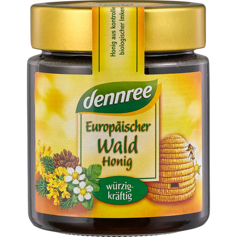 Ein Glas mit goldenem Waldhonig, umgeben von einem natürlichen Waldhintergrund. Der Honig hat eine reichhaltige, dunkle Farbe und eine dickflüssige Konsistenz, die seine hohe Qualität und Reinheit widerspiegelt.