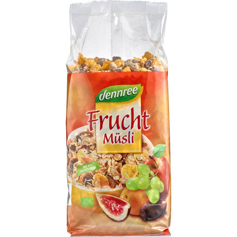 Eine Schüssel mit Früchte Müsli, gefüllt mit Haferflocken, getrockneten Früchten wie Rosinen, Aprikosen und Äpfeln, sowie Nüssen und Samen, auf einem Holztisch arrangiert.