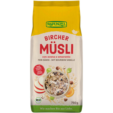 Schale mit Bircher Müsli, gefüllt mit Haferflocken, frischen Früchten und Nüssen, serviert auf einem rustikalen Holztisch.