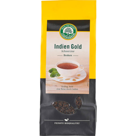 Indien Gold Schwarztee in einer eleganten Verpackung, präsentiert mit losen Teeblättern und einer Tasse frisch gebrühten Tees, der für seinen reichen, kräftigen Geschmack und seine goldene Farbe bekannt ist.