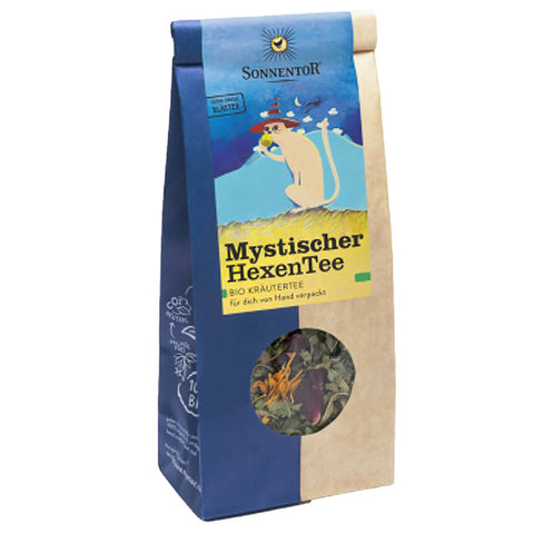 Mystischer Hexentee in einer dekorativen Verpackung, umgeben von magischen Kräutern und funkelnden Sternen, ideal für entspannende und spirituelle Teemomente.