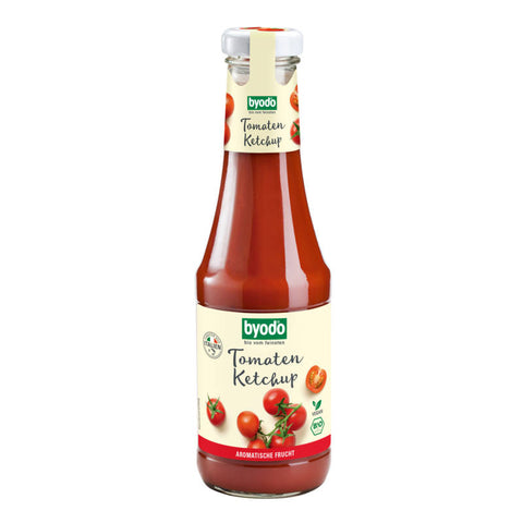 Flasche Tomaten-Ketchup mit rotem Etikett und frischen Tomaten im Hintergrund