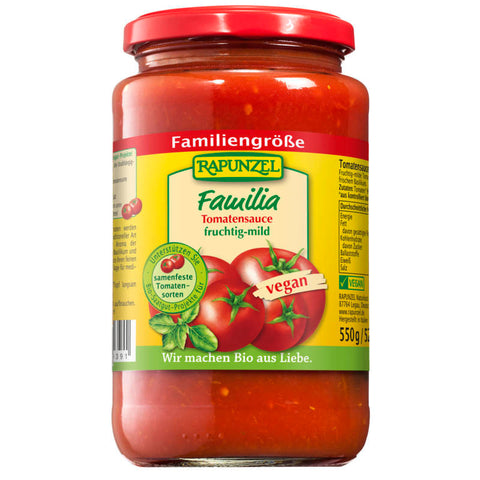 Glas Tomatensauce Familia mit frischen Tomaten und Kräutern auf einem Holztisch