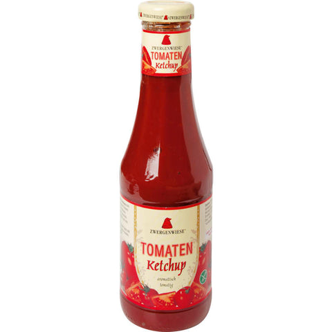 Flasche Tomaten-Ketchup mit rotem Etikett und frischen Tomaten im Hintergrund