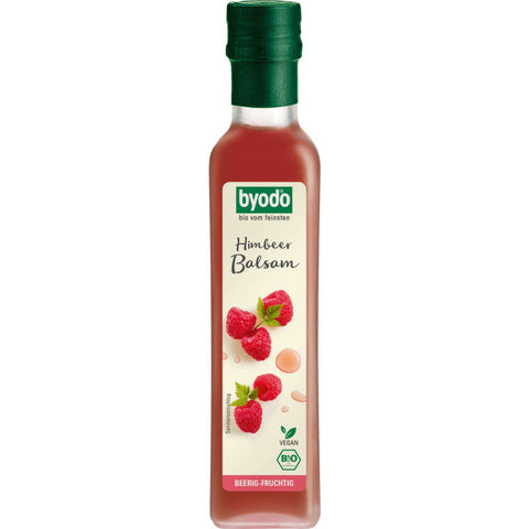 Flasche Himbeer Balsam Essig mit frischen Himbeeren im Hintergrund