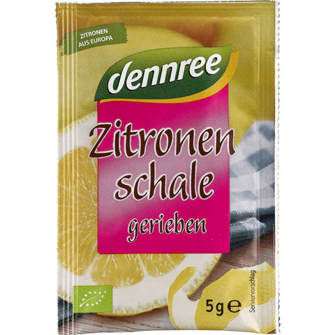 Geriebene Zitronenschale in einer kleinen Schüssel, perfekt zum Verfeinern von Backwaren und Gerichten mit einem frischen, zitronigen Aroma.