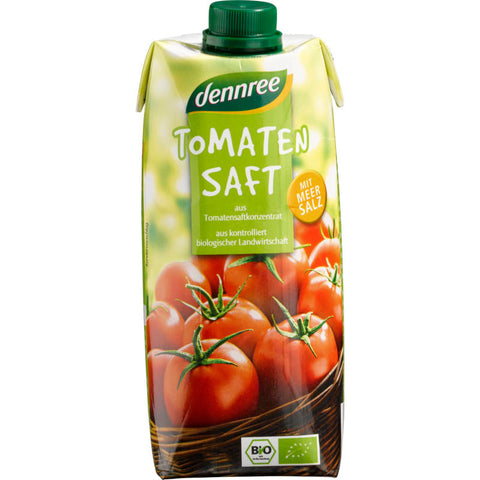 Eine Flasche Tomatensaft mit frischen, reifen Tomaten im Hintergrund